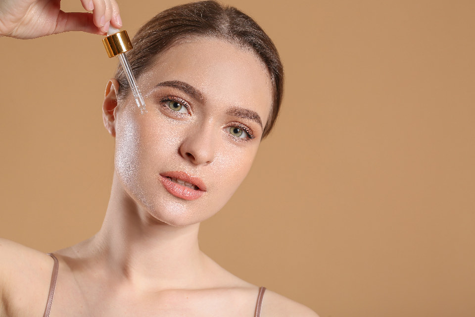 Woman applying serum to her cheek